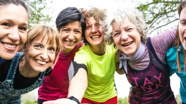 A group of smiling women taking a selfie together.