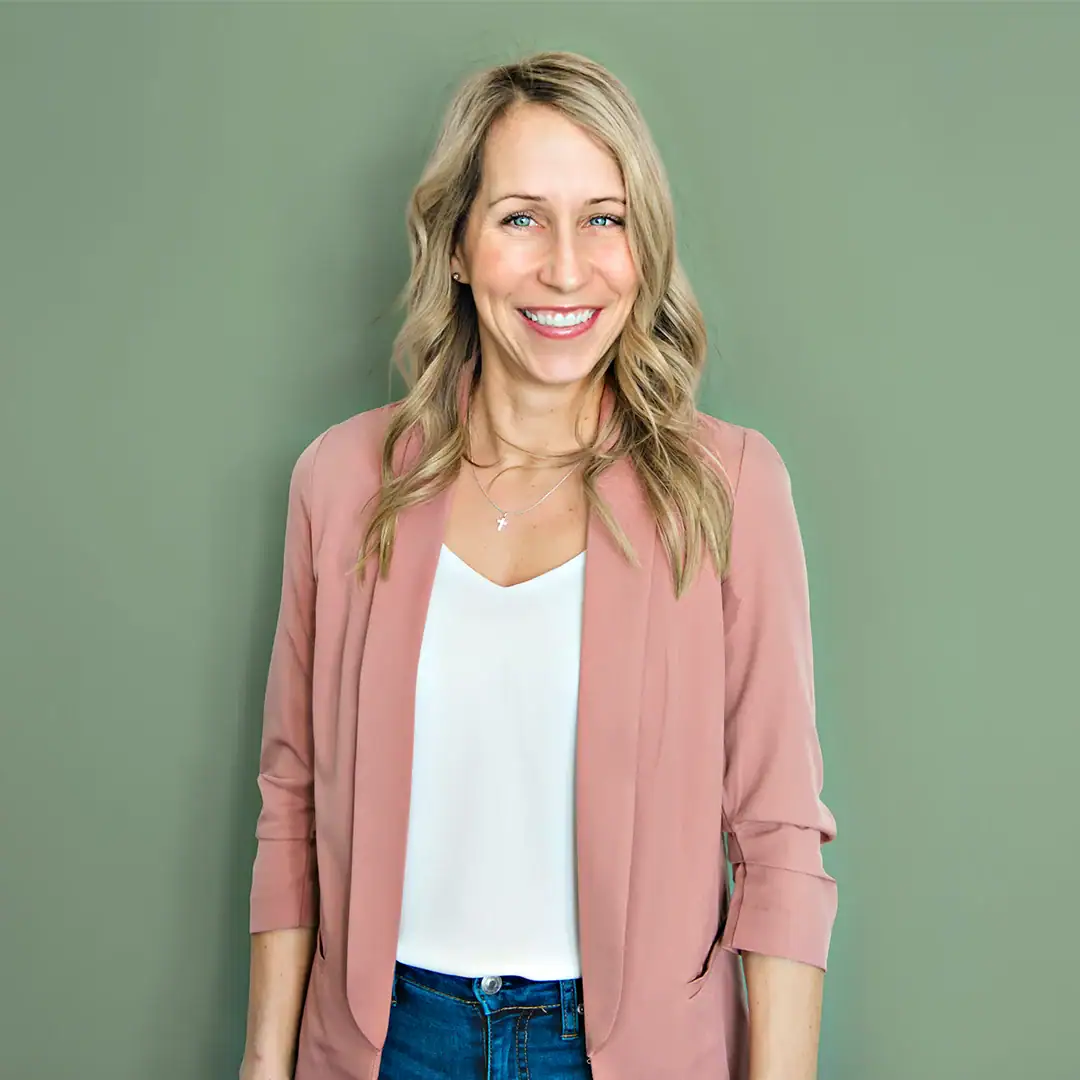 Smiling woman in professional attire promoting longevity and wellness.