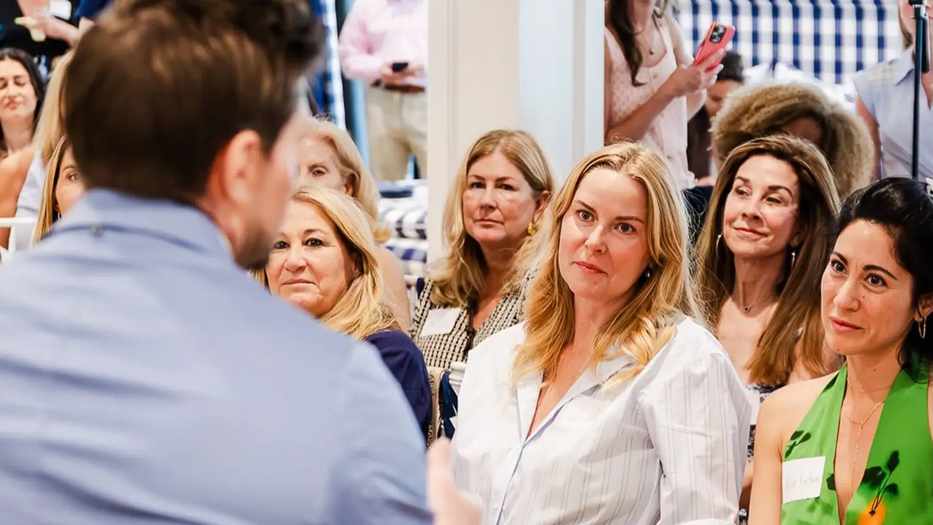 Attendees listen attentively during a wellness presentation, focusing on a speaker in the foreground.